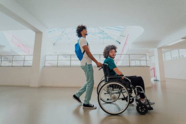 Afrikalı Amerikalı bir öğrenci, arkadaşlarını tekerlekli sandalyeyle modern bir okula sokuyor. Engelli insanlara yardım etme gücünü, ulaşılabilirliğini ve arkadaşlığın gücünü gösteriyor..