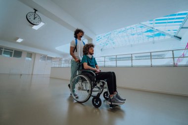 Afrikalı Amerikalı bir öğrenci, arkadaşlarını tekerlekli sandalyeyle modern bir okula sokuyor. Engelli insanlara yardım etme gücünü, ulaşılabilirliğini ve arkadaşlığın gücünü gösteriyor..