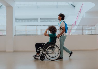 Afrikalı Amerikalı bir öğrenci, arkadaşlarını tekerlekli sandalyeyle modern bir okula sokuyor. Engelli insanlara yardım etme gücünü, ulaşılabilirliğini ve arkadaşlığın gücünü gösteriyor..