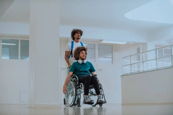 Afroamerykanin Popycha Swoich Przyjaciół Wózku Inwalidzkim Przez Nowoczesną Szkołę Demonstrując — Zdjęcie stockowe