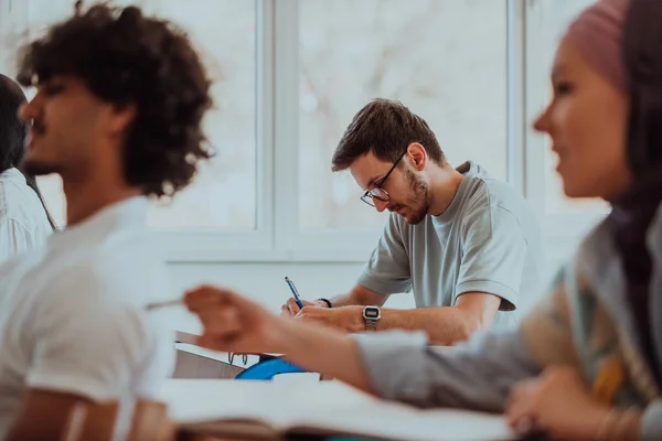 stock image A group of diverse students engages in lively discussion as they educate themselves in a modern classroom, embracing the power of collaboration and knowledge exchange