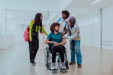 Modern bir üniversitede, aralarında Afrikalı Amerikalı bir öğrenci ve tesettürlü bir kadının da bulunduğu bir grup öğrenci, tekerlekli sandalyeye mahkum meslektaşlarıyla birlikte koridorda yürüyorlar..