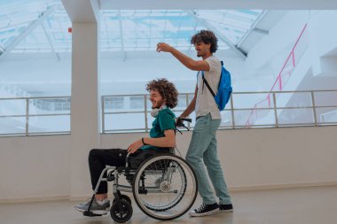 Afrikalı Amerikalı bir öğrenci, arkadaşlarını tekerlekli sandalyeyle modern bir okula sokuyor. Engelli insanlara yardım etme gücünü, ulaşılabilirliğini ve arkadaşlığın gücünü gösteriyor..