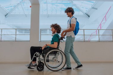 Afrikalı Amerikalı bir öğrenci, arkadaşlarını tekerlekli sandalyeyle modern bir okula sokuyor. Engelli insanlara yardım etme gücünü, ulaşılabilirliğini ve arkadaşlığın gücünü gösteriyor..