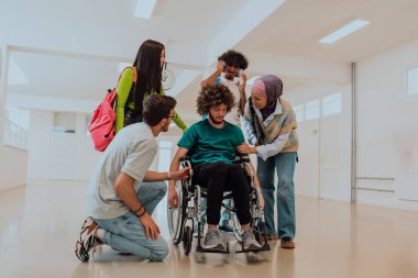 Modern bir üniversitede, aralarında Afrikalı Amerikalı bir öğrenci ve tesettürlü bir kadının da bulunduğu bir grup öğrenci, tekerlekli sandalyeye mahkum meslektaşlarıyla birlikte koridorda yürüyorlar..