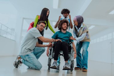 Modern bir üniversitede, aralarında Afrikalı Amerikalı bir öğrenci ve tesettürlü bir kadının da bulunduğu bir grup öğrenci, tekerlekli sandalyeye mahkum meslektaşlarıyla birlikte koridorda yürüyorlar..