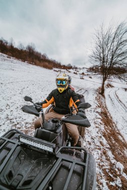 Genç ve maceraperest bir çift, karlı dağlık arazide ATV Quad sürerken aşkın ve heyecanın neşesini kucaklıyor.. 