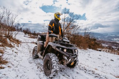 Genç ve maceraperest bir çift, karlı dağlık arazide ATV Quad sürerken aşkın ve heyecanın neşesini kucaklıyor.. 