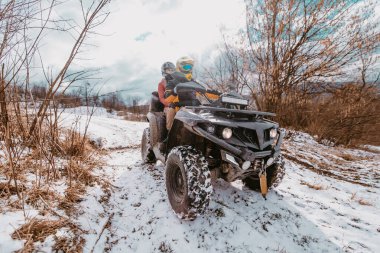 Genç ve maceraperest bir çift, karlı dağlık arazide ATV Quad sürerken aşkın ve heyecanın neşesini kucaklıyor.. 