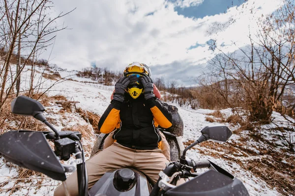 若い冒険的なカップルは 雪の山岳地形を介してAtvクワッドに乗るように愛とスリルの喜びを受け入れます — ストック写真