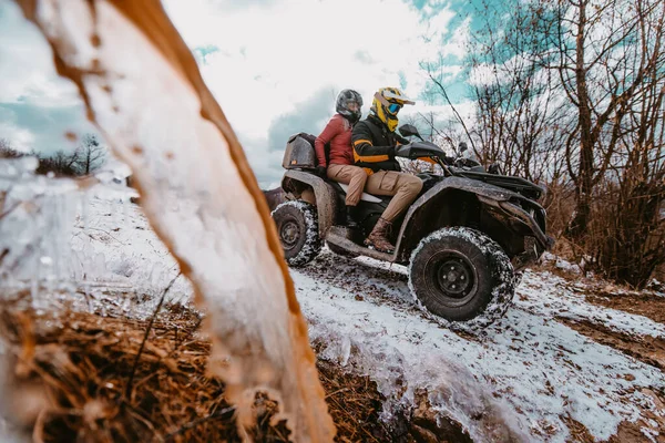一对充满冒险精神的年轻夫妇乘坐Atv四驱车穿越雪山时 拥抱着爱和兴奋的喜悦 — 图库照片
