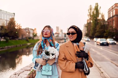 Birinde tesettür ve modern ama geleneksel bir elbise, diğerinde ise mavi bir elbise ve eşarp giyip gün batımında şehirde birlikte yürüyen bir çift. Biri bir buket ekmek taşırken,