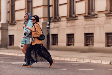 Birinde tesettür ve modern ama geleneksel bir elbise, diğerinde ise mavi bir elbise ve eşarp giyip gün batımında şehirde birlikte yürüyen bir çift. Biri bir buket ekmek taşırken,