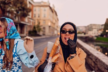 Birinde tesettür ve modern ama geleneksel bir elbise, diğerinde ise mavi bir elbise ve eşarp giyip gün batımında şehirde birlikte yürüyen bir çift. Biri bir buket ekmek taşırken,