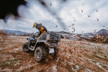 Bir adam tehlikeli karlı arazide korkusuzca ATV Avlusu 'nda maceralı bir yolculuktan zevk alıyor. Zorlu dağ manzarasının heyecanını ve heyecanını kucaklıyor.. 