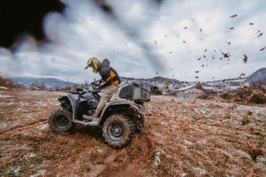 Bir adam tehlikeli karlı arazide korkusuzca ATV Avlusu 'nda maceralı bir yolculuktan zevk alıyor. Zorlu dağ manzarasının heyecanını ve heyecanını kucaklıyor.. 