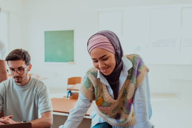 Başörtüsü takan bir iş kadını geniş bir tebessümle kurumsal bir toplantıya liderlik ediyor, profesyonelliğini, özgüvenini ve modern kıyafete dahil liderliğini gösteriyor.. 