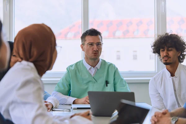 A dedicated group of doctors and medical nurses attentively listens to their colleagues work plan in a healthcare facility, fostering collaboration and ensuring high-quality patient care.