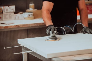 Marangozluk endüstrisindeki yetenekli bir zanaatkar, bir ahşap cilası makinesini titizlikle çalıştırıyor, ustalığını ve ince üretimde kusursuz bir sonuç elde etmeye olan bağlılığını sergiliyor.