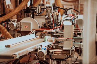 Modern bir ahşap işleme tesisinde, modern bir CNC makinesinde kusursuz bir hassas teknoloji ve geleneksel zanaatkarlık sergileniyor, çeşitli bir dizi üretmek için uyum içinde çalışıyor.