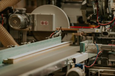 Modern bir ahşap işleme tesisinde, modern bir CNC makinesinde kusursuz bir hassas teknoloji ve geleneksel zanaatkarlık sergileniyor, çeşitli bir dizi üretmek için uyum içinde çalışıyor.