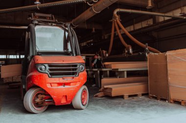 Bir forklift, ahşap ürünleri verimli bir şekilde yüksek kaliteli kapılar üretmek üzere tasarlandıkları ahşap fabrikasına taşır.