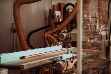 Modern bir ahşap işleme tesisinde, modern bir CNC makinesinde kusursuz bir hassas teknoloji ve geleneksel zanaatkarlık sergileniyor, çeşitli bir dizi üretmek için uyum içinde çalışıyor.