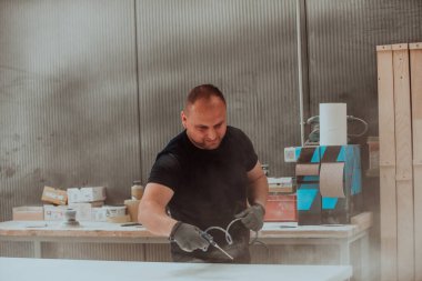 Ahşap işçiliği sektöründeki kendini işine adamış bir işçi, son aşamada titizlikle temizlenmiş ahşap ürünleri kullanmak için sıkıştırılmış hava kullanır. Bu da zanaatkarlığın detaylarına hassasiyet ve dikkat göstermektedir.