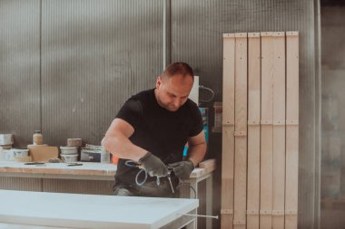 Ahşap işçiliği sektöründeki kendini işine adamış bir işçi, son aşamada titizlikle temizlenmiş ahşap ürünleri kullanmak için sıkıştırılmış hava kullanır. Bu da zanaatkarlığın detaylarına hassasiyet ve dikkat göstermektedir.