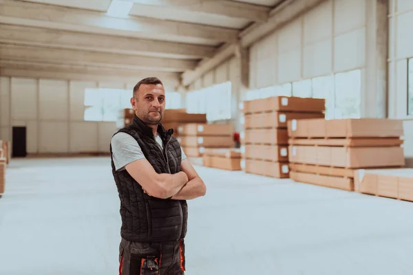 A skilled worker in the woodworking industry is captured within the confines of a lumber-filled warehouse, providing a glimpse into the dedicated craftsmanship and industrial atmosphere that defines