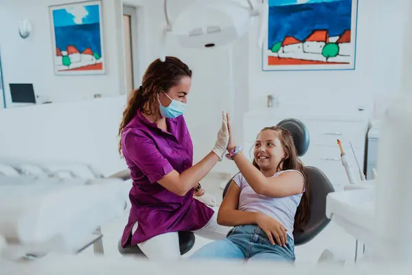 İlgili bir dişçi neşeli bir sohbete girişir ve diş tedavisinden sonra küçük bir kızı eğlendirir. Diş muayenehanesinde dostane ve keyifli bir ortam yaratır.