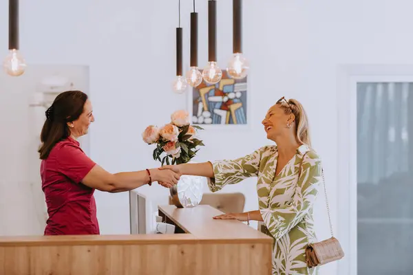 Güzel sarışın, diş muayenesinden sonra diş hekiminin bir çalışanıyla tokalaşıyor.. 