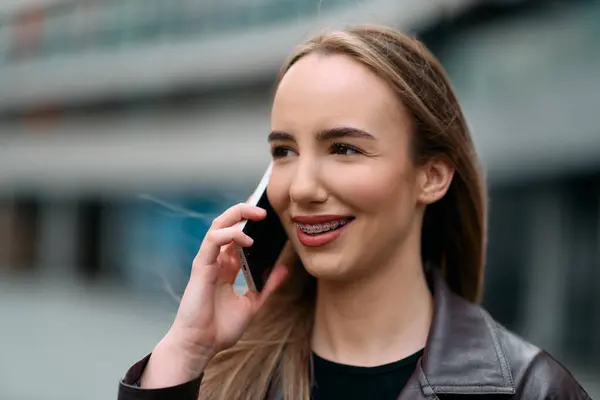 Business Woman With Phone Near Office. Portrait Of Beautiful Smiling Female In Fashion Office Clothes Talking On Phone While Standing Outdoors. Phone Communication