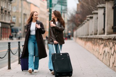 İki kadın turist bir Avrupa şehrini keşfediyor, bavullarını çekerek büyüleyici caddelerde geziniyorlar, kendilerini seyahat yerlerinin kültürüne ve güzelliğine kaptırıyorlar..