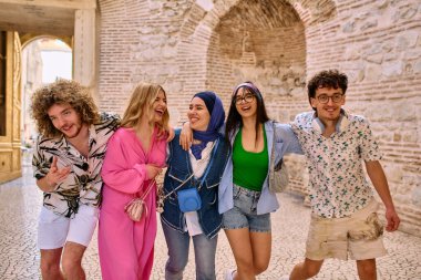 Yaz kıyafetleri içinde çeşitli turist grupları, geniş tebessümleriyle turistik şehirde geziniyor, gezintilerinin tadını çıkarıyorlar.. 