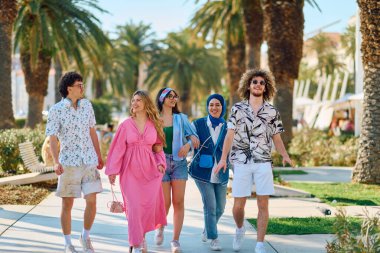 Yaz kıyafetleri içinde çeşitli turist grupları, geniş tebessümleriyle turistik şehirde geziniyor, gezintilerinin tadını çıkarıyorlar.. 