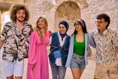 Yaz kıyafetleri içinde çeşitli turist grupları, geniş tebessümleriyle turistik şehirde geziniyor, gezintilerinin tadını çıkarıyorlar.. 