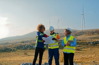 A team of engineers and workers oversees a wind turbine project at a modern wind farm, working together to ensure the efficient generation of renewable energy.  clipart