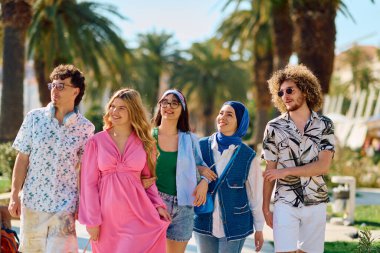 Yaz kıyafetleri içinde çeşitli turist grupları, geniş tebessümleriyle turistik şehirde geziniyor, gezintilerinin tadını çıkarıyorlar.. 