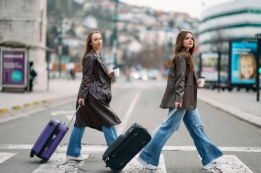 İki kadın turist bir Avrupa şehrini keşfediyor, bavullarını çekerek büyüleyici caddelerde geziniyorlar, kendilerini seyahat yerlerinin kültürüne ve güzelliğine kaptırıyorlar..