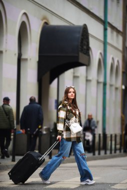 Bavullu güzel bir kadın Avrupa şehirlerine turist gezisine gider, turizm konseptine, seksi bir kadın modern turistik yerlere gider, bir kadın modern Avrupa şehrinin sokaklarından zevk alır.. 