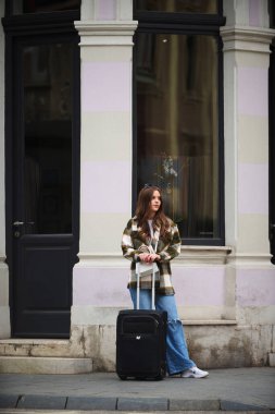 Bavullu güzel bir kadın Avrupa şehirlerine turist gezisine gider, turizm konseptine, seksi bir kadın modern turistik yerlere gider, bir kadın modern Avrupa şehrinin sokaklarından zevk alır.. 