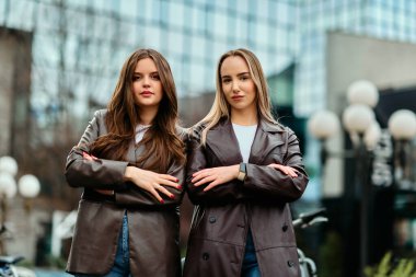 İki başarılı iş kadını şirket binalarının önünde gururla poz veriyor, başarılarını kutluyor ve diğerlerine ilham veriyor.. 