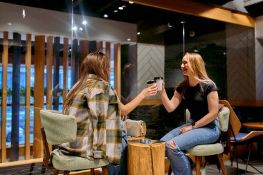 İki arkadaş, uzun bir iş gününden sonra sıcak bir kafede kahve içip sohbet etmekten zevk alırlar.. 