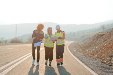 Mühendis ve işçilerden oluşan bir ekip, yenilenebilir enerjinin verimli bir şekilde üretilmesini sağlamak için birlikte çalışan modern bir rüzgâr çiftliğinde rüzgar türbini projesini denetliyor.. 