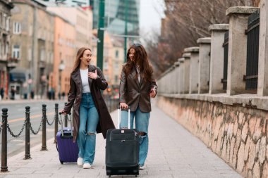 İki kadın turist bir Avrupa şehrini keşfediyor, bavullarını çekerek büyüleyici caddelerde geziniyorlar, kendilerini seyahat yerlerinin kültürüne ve güzelliğine kaptırıyorlar..