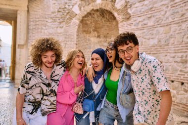 Yaz kıyafetleri içinde çeşitli turist grupları, geniş tebessümleriyle turistik şehirde geziniyor, gezintilerinin tadını çıkarıyorlar.. 