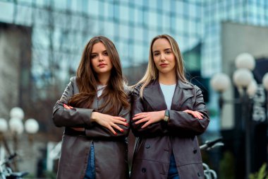 İki başarılı iş kadını şirket binalarının önünde gururla poz veriyor, başarılarını kutluyor ve diğerlerine ilham veriyor.. 