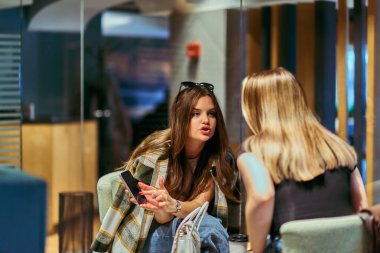 İki arkadaş en sevdikleri kafede buharlı kahve içerken bir an iletişim ve kahkaha paylaşıyorlar.. 