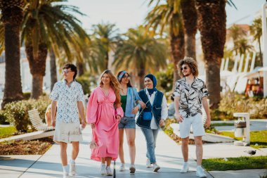 Yaz kıyafetleri içinde çeşitli turist grupları, geniş tebessümleriyle turistik şehirde geziniyor, gezintilerinin tadını çıkarıyorlar.. 